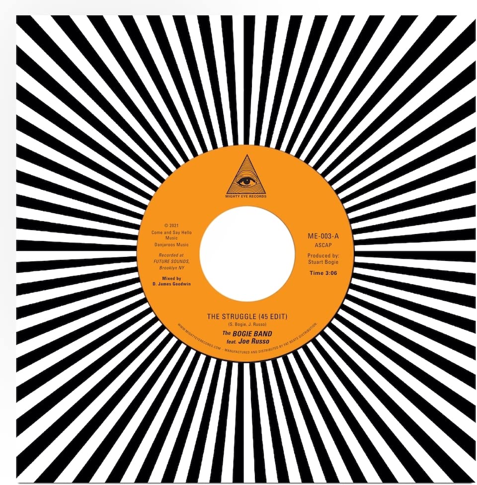 Vinyl record label with orange background and black text over a black-and-white sunburst pattern.