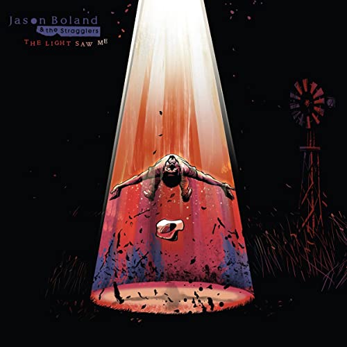 A person floats in a bright beam of light near a windmill at night.