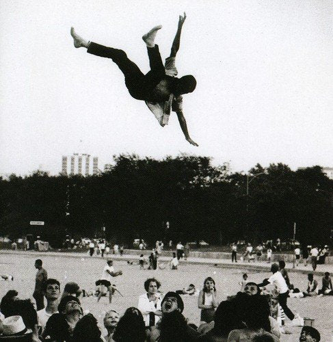 "Album cover with man flipping in air, crowd in park below, blue text overlay."