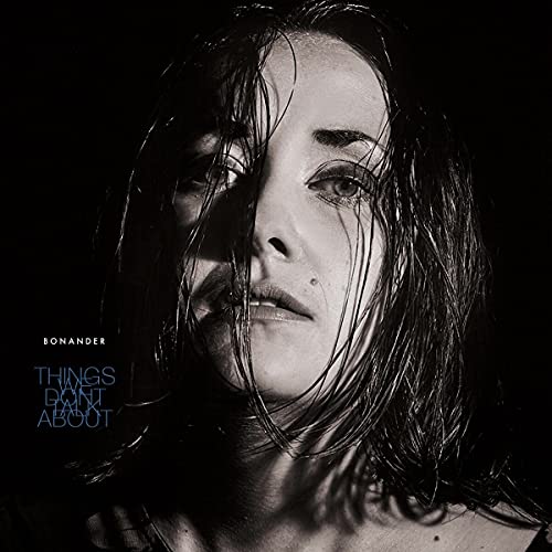 Black and white portrait of a woman with wet hair, album cover.