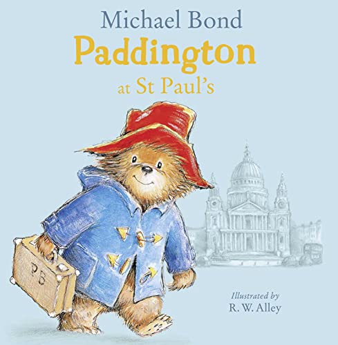 Paddington Bear in a blue coat and red hat carrying a suitcase near St Paul's.