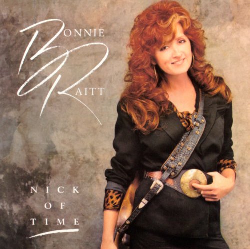 Bonnie Raitt with long red hair wearing a black jacket on album cover art.