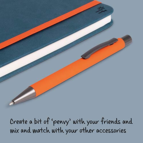 An orange pen with a dark grey clip next to a blue notebook.