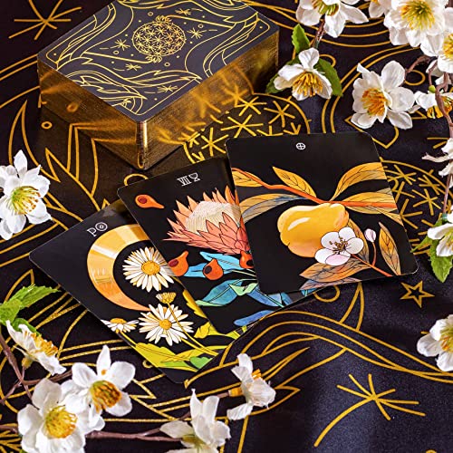 Tarot deck with floral illustrations rests among blossoming branches.