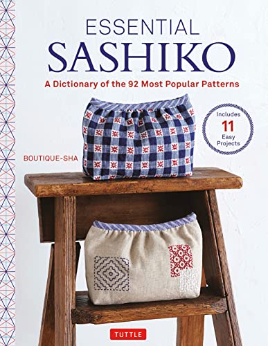 Sashiko pattern book with examples of embroidered bags on a stool.
