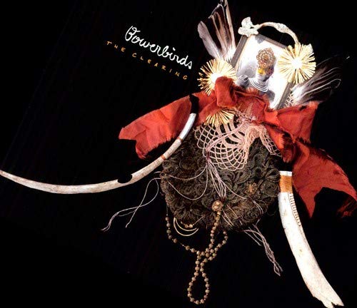 Bowerbirds album cover, "The Clearing," featuring ornate, decorated mask imagery.