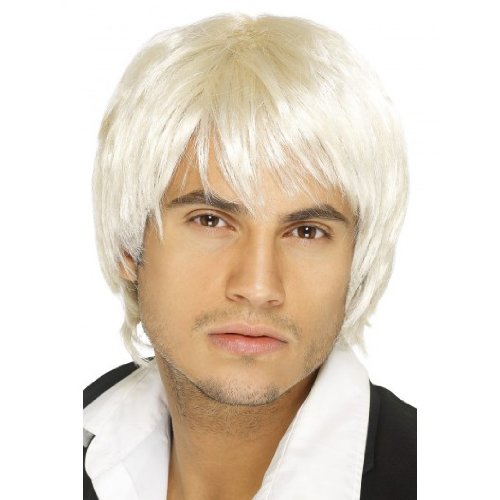 Man wearing a white, shaggy wig, black jacket, and white shirt, against a white background.