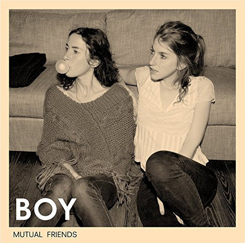 Two young women seated on a couch, sepia tone, album cover.