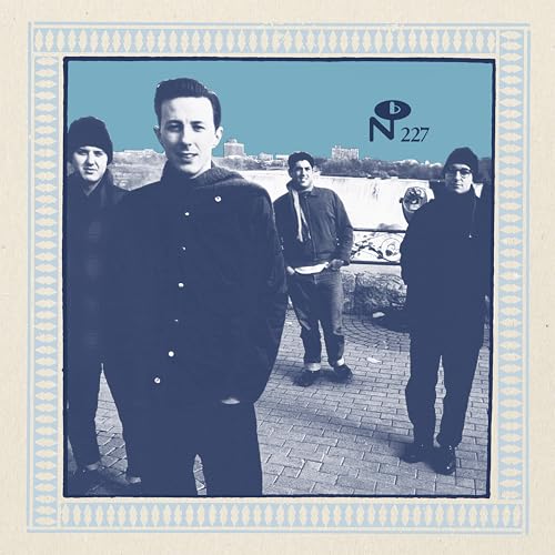 Four men stand on a brick plaza in this blue-toned vinyl album cover.