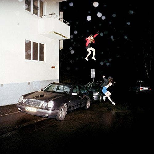 CD cover: people levitating near a building and parked cars at night.