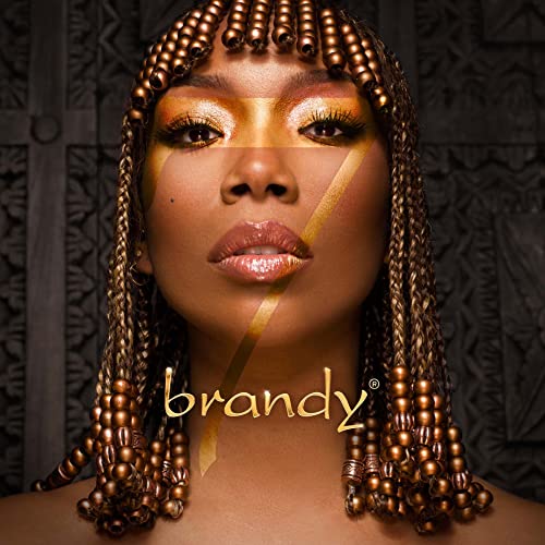 Brandy album cover, close-up of singer with beaded hair and gold makeup.