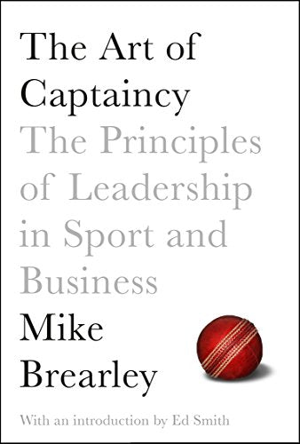 The image shows a book cover with a red cricket ball on a white background.