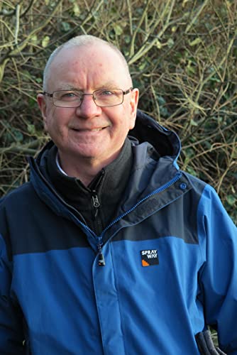 Headshot of a smiling older man wearing a blue and black jacket.