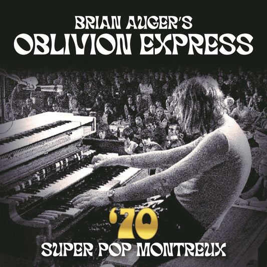 Black and white photo of Brian Auger playing keyboards before a live audience.