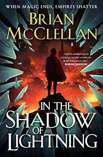 A silhouetted figure stands before a fiery city, framed by shards of broken glass.