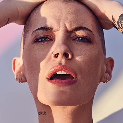 Close-up portrait of a person with short hair and tattoos.