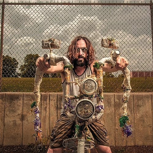 A man with long hair and a beard holds makeshift handlebars in front of him.