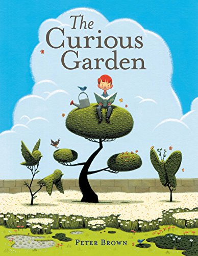 A boy sits on a topiary tree reading a book in a lush garden.