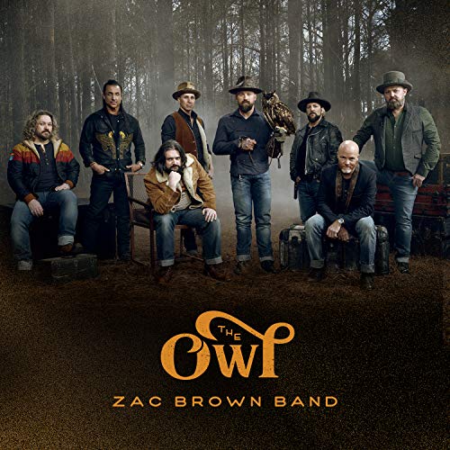 Zac Brown Band posing with an owl in a wooded setting.