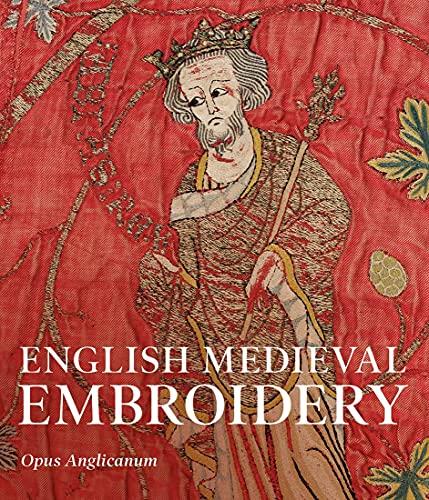 Detail of an embroidered medieval figure wearing a crown against a red fabric background.