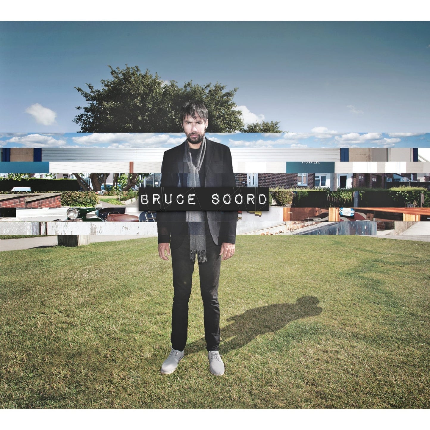 Bruce Soord album cover featuring a man standing in front of buildings.