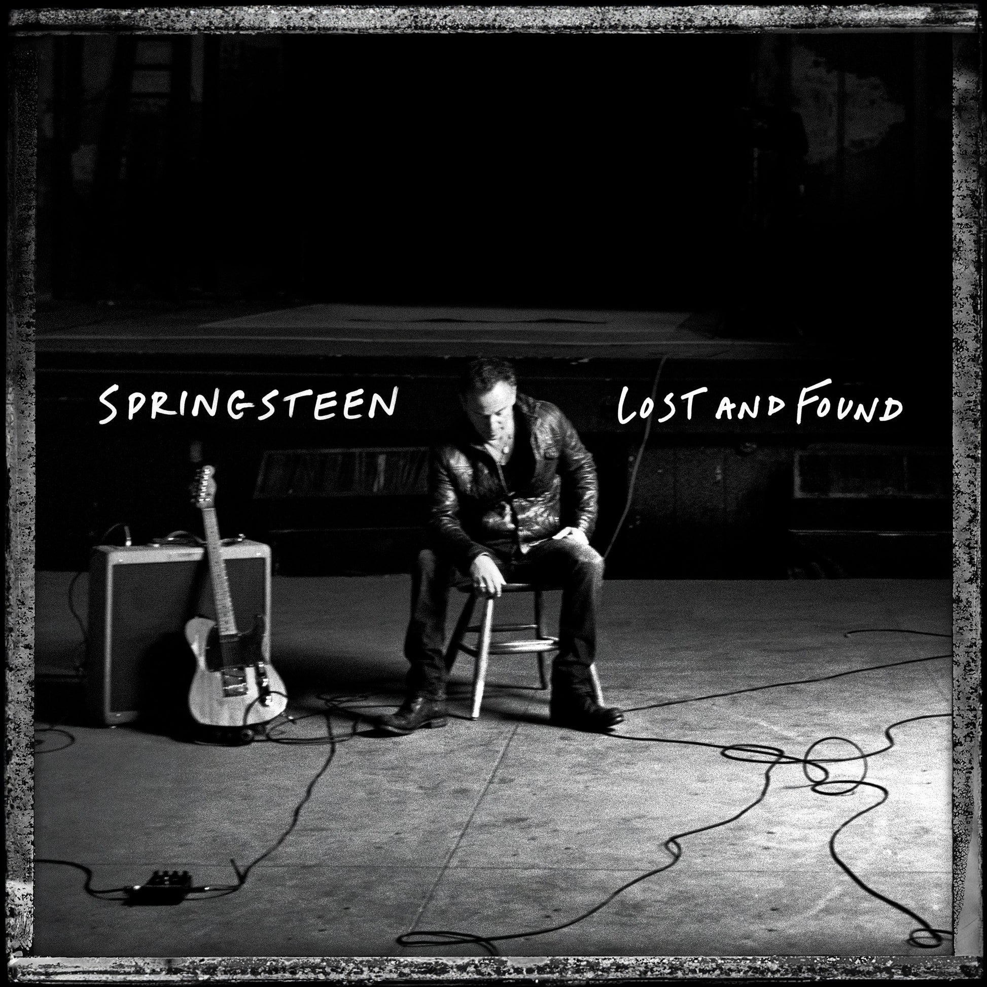 Black and white album cover featuring Bruce Springsteen sitting with a guitar.