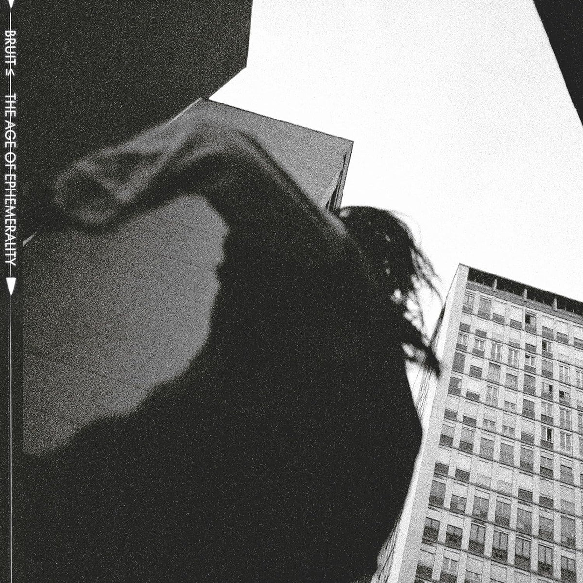 Black and white CD cover with a person’s face and city buildings.