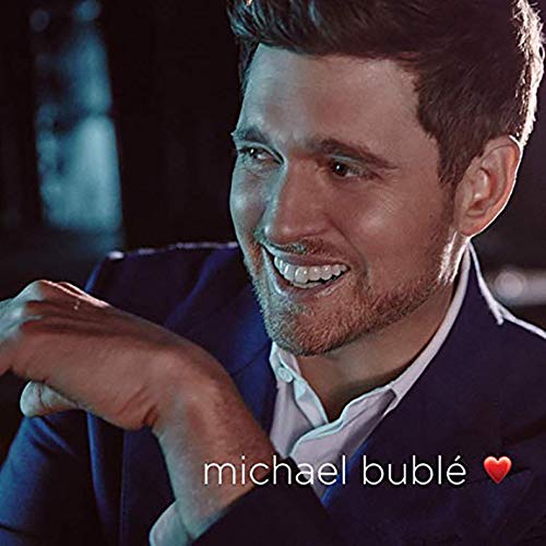 Michael Bublé smiling, wearing a suit, with a red heart graphic.