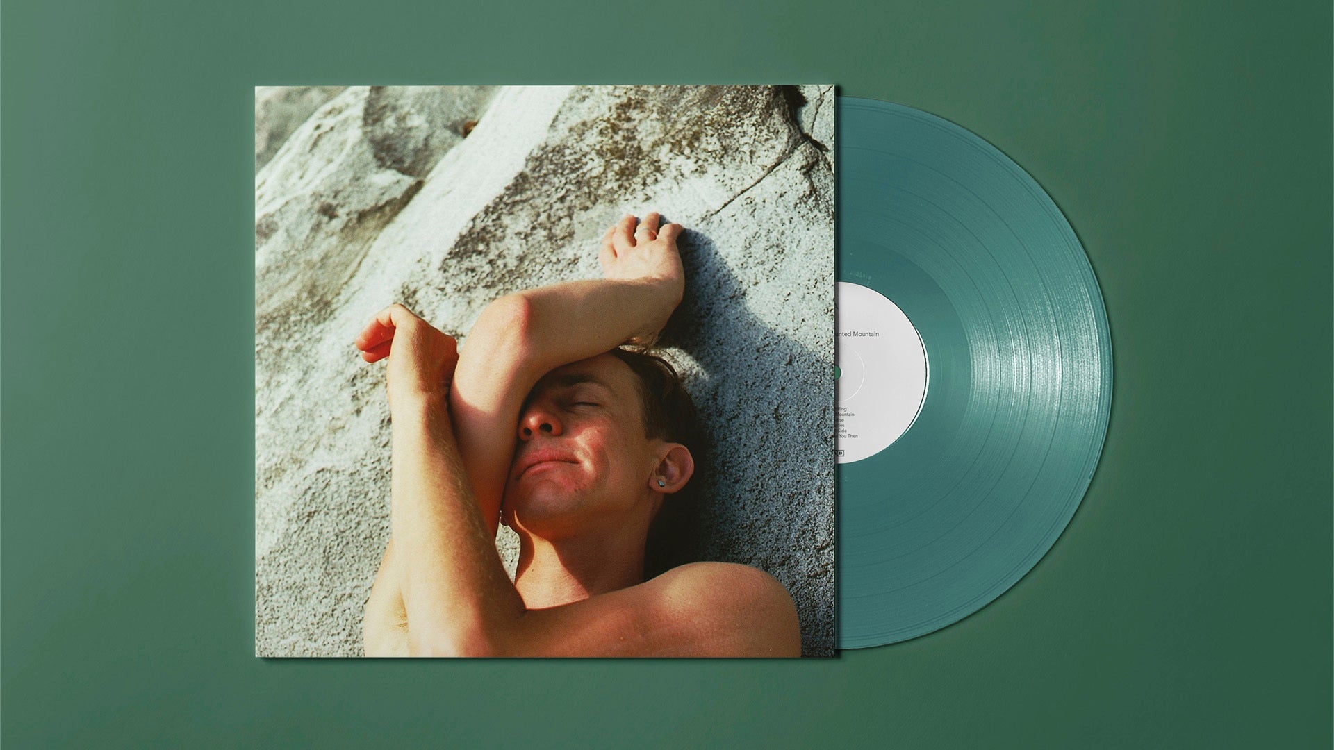 Vinyl record with album cover showing a person lying on rocks.