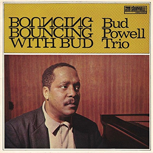 "Vinyl album cover featuring a man in a suit, sitting at a piano."