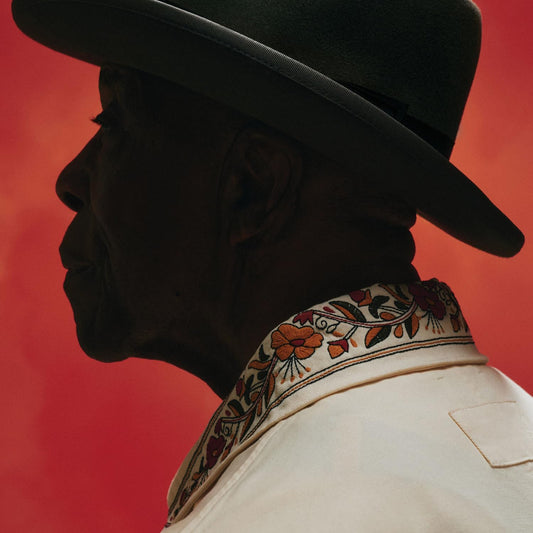 Buddy Guy in profile wearing a black hat and embroidered shirt.