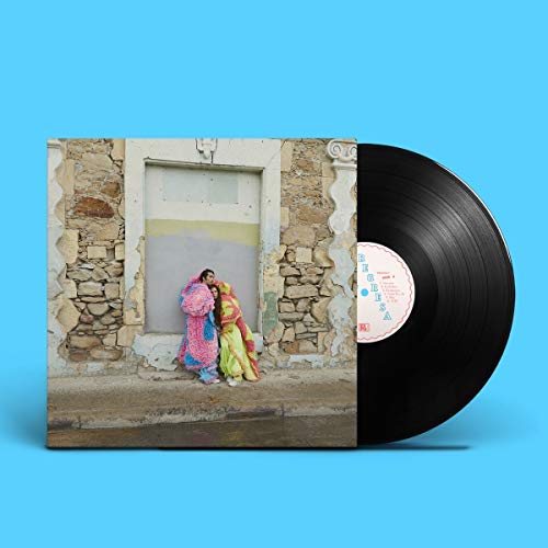 Vinyl record and cover showing two people hugging against a weathered stone wall.