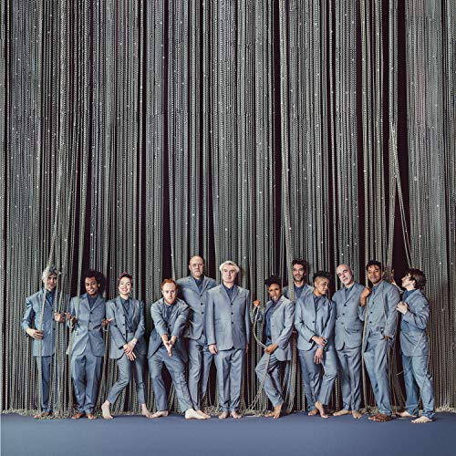 Album cover with 12 men in grey suits standing in front of a curtain.