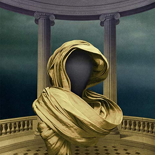 Statue with headless black bust wrapped in flowing gold cloth on balcony.
