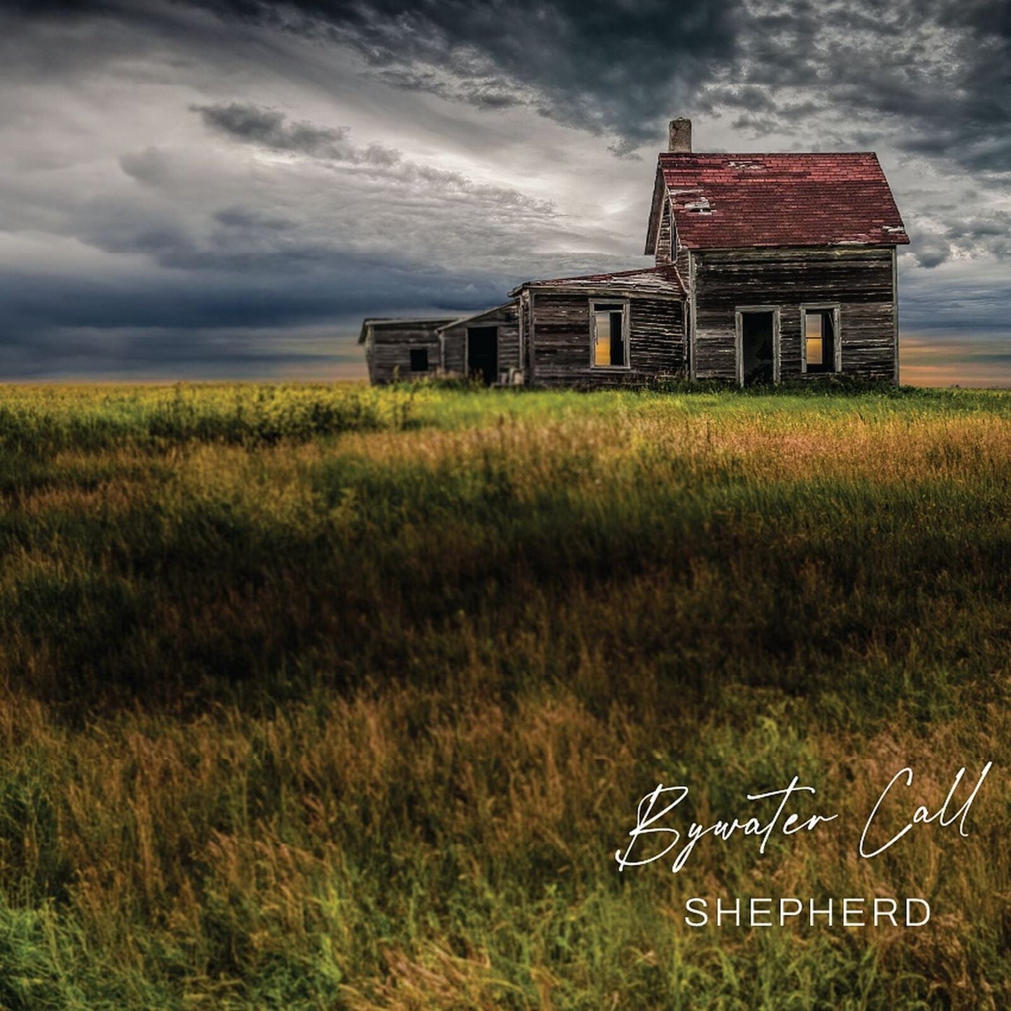 Dilapidated wooden house in a grassy field under a stormy sky.