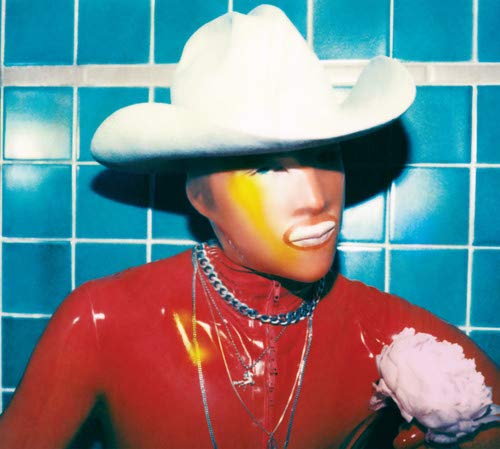 Person in red wearing a white cowboy hat and yellow face paint.
