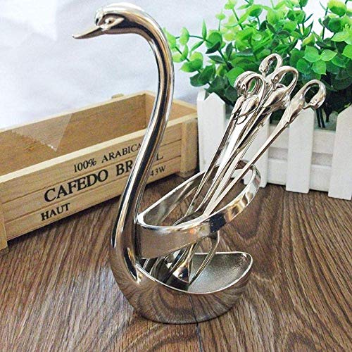 Silver swan-shaped sugar tongs and spoons displayed on a wood surface.