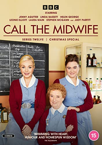 Three women in midwife uniforms and cardigans standing in a room with a blackboard.