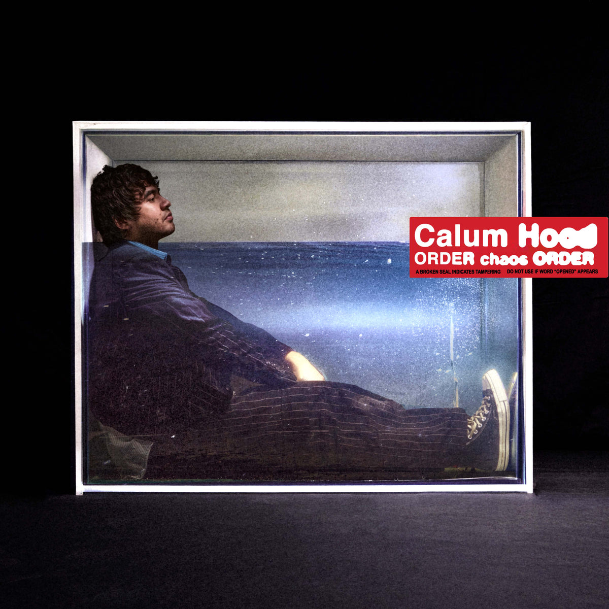 Calum Hood album cover: man in a box by the sea.