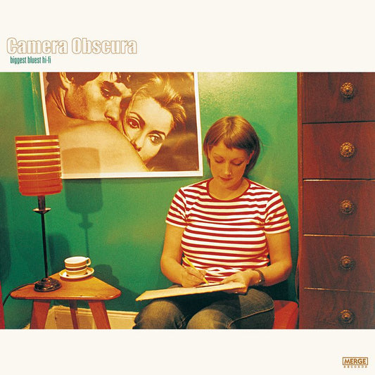 Album cover: woman writing, framed portrait, lamp, and green wall.