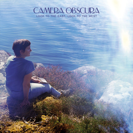 CD cover: woman sitting on rocks overlooking blue water.