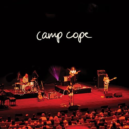 Camp Cope performing live on stage with instruments and stage lighting.