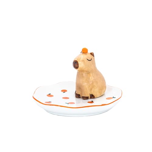 Ceramic capybara figurine on a small, orange-decorated white dish.