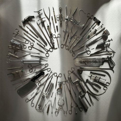 Arrangement of vintage surgical tools in a circular pattern on gray.