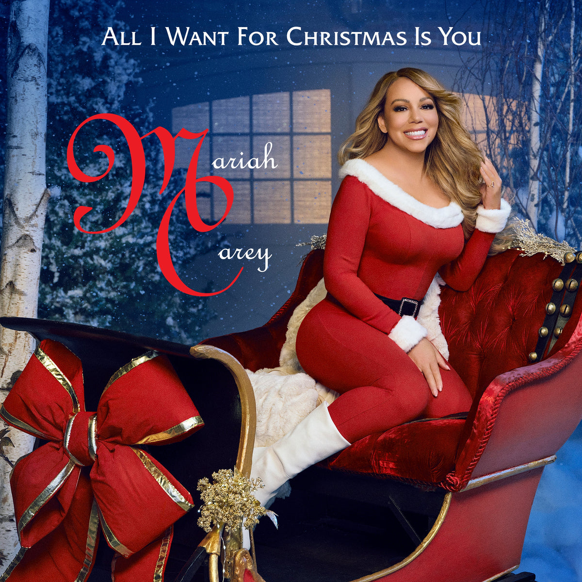 Mariah Carey in red suit, posing on a sleigh in winter scene.