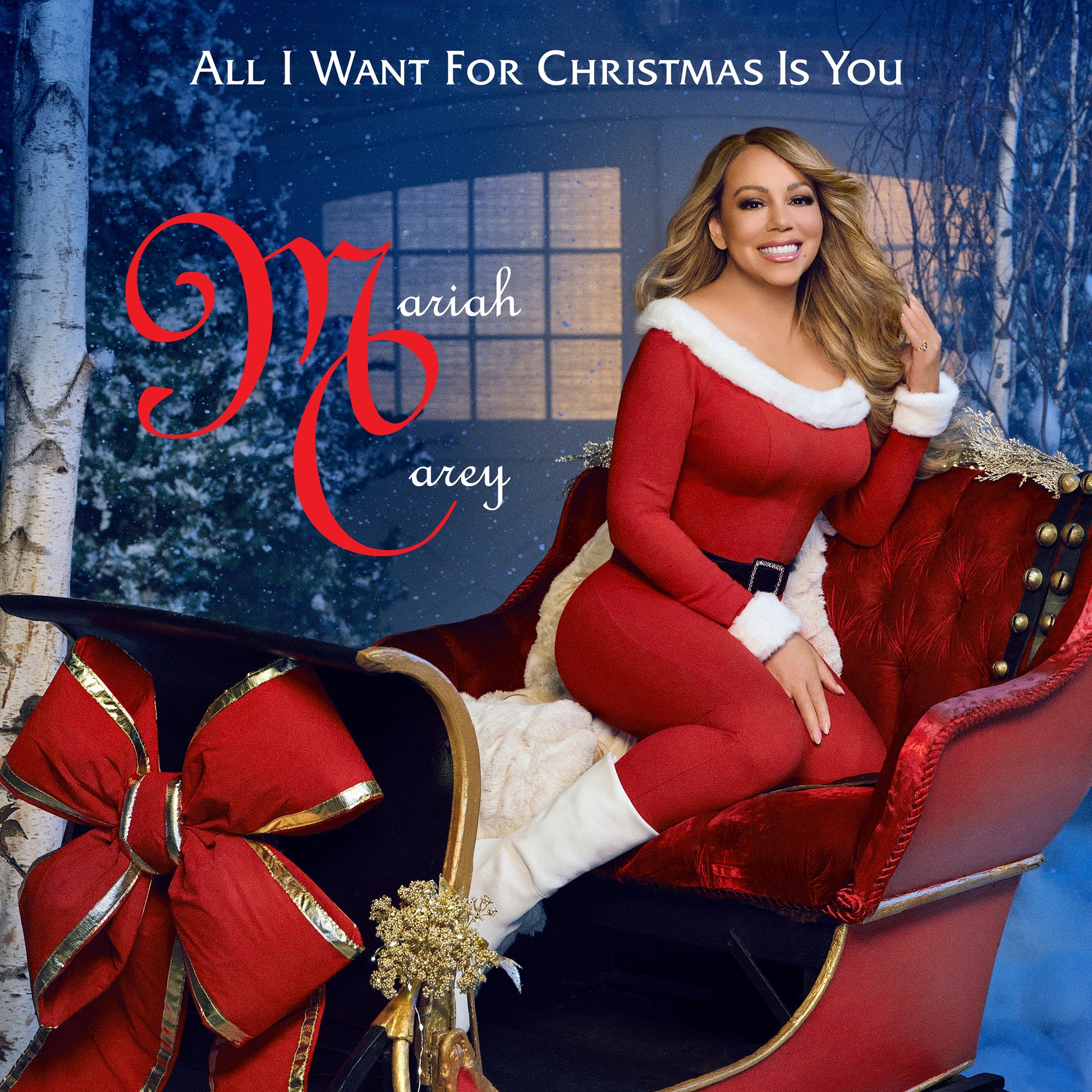 Mariah Carey in red suit, posing on a sleigh in winter scene.