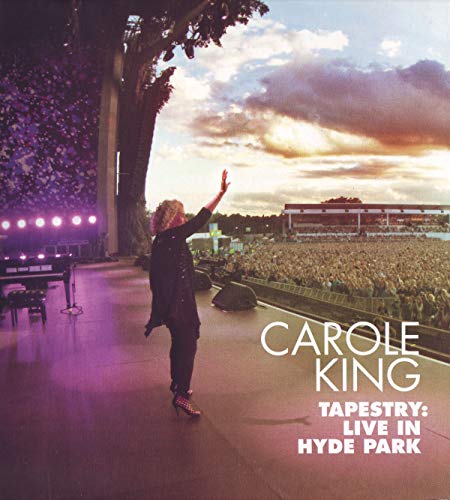 Carole King performing on stage at Hyde Park with a large crowd.