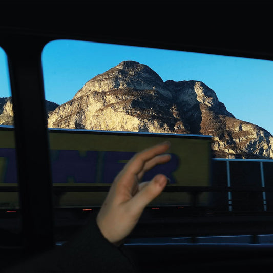 CD cover with a mountain view framed by a car window and hand.