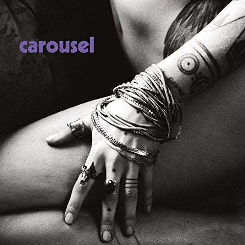 Black and white album cover with arm, hands, rings, and tattoos.