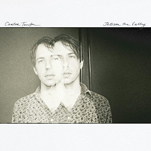 Double exposure portrait of a man in a patterned shirt on album cover.